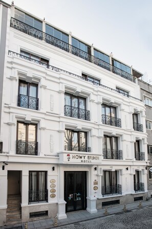 A white building with balconies, a sign reading "NOWY EFENDI HOTEL," and a cobblestone street. - Nowy Efendi Hotel - Special Class (Istanbul)