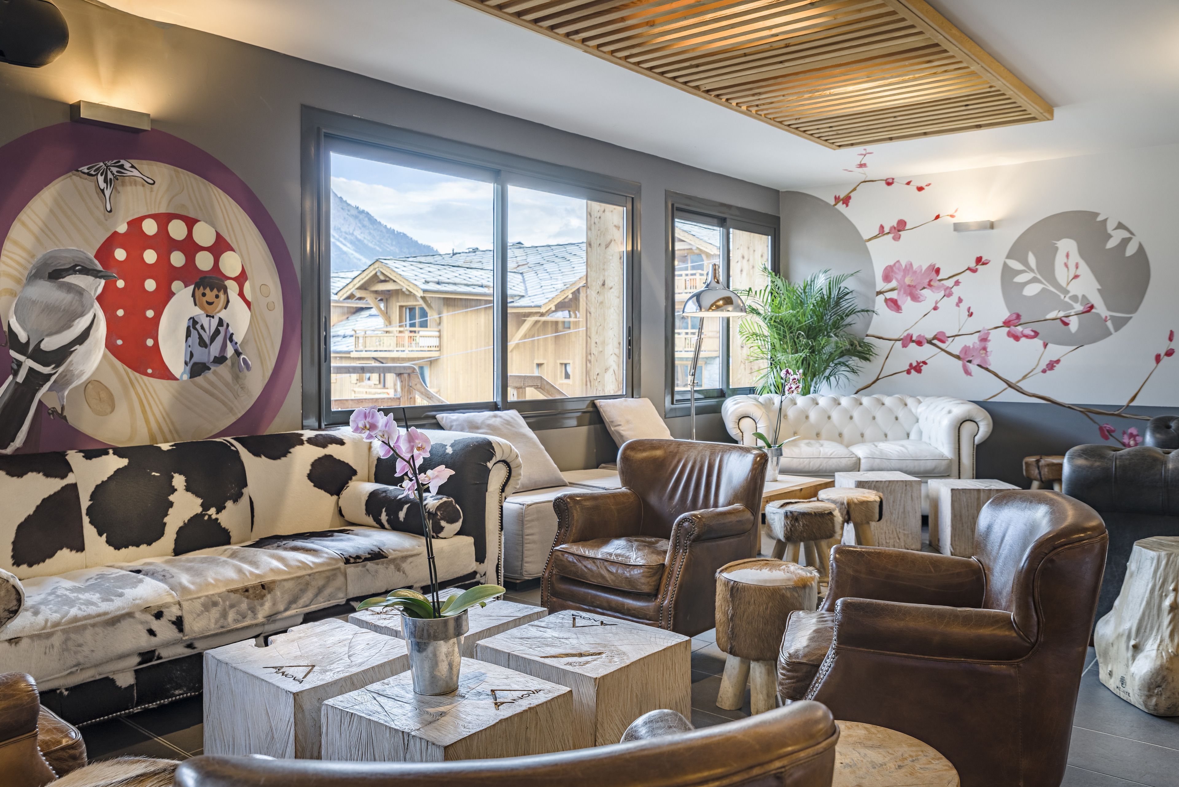 A modern living room with a sofa, leather chairs, and a coffee table.
