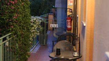 An outdoor patio with a table and chairs, a fire extinguisher, and a sign that reads "PRIVE."