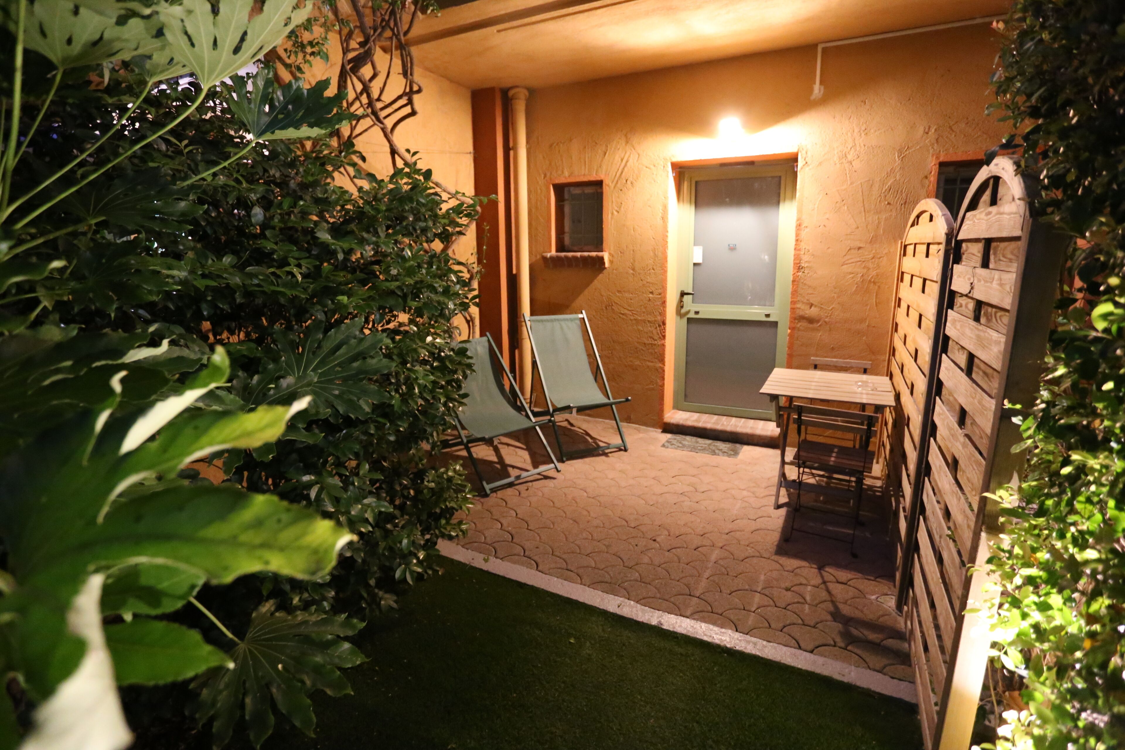 A patio area with a table and chairs, a door, and a small window.