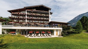 Un hotel a più piani con posti a sedere all'aperto e fioriere sui balconi.
