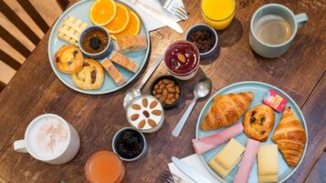 Una mesa de desayuno con platos de comida, bebidas y salsas.