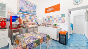 A kitchen with a colorful tiled backsplash, a coffee machine, and a clock on the wall. - B&B Casa Nilde Positano (Positano)