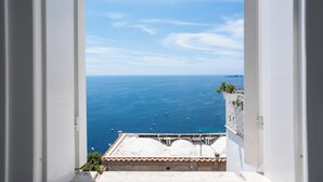 A view from a window overlooking a coastal area with a clear sky and calm sea. - B&B Casa Nilde Positano (Positano)