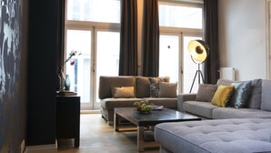 Una sala de estar moderna con sofá, mesa de centro y lámpara de pie.