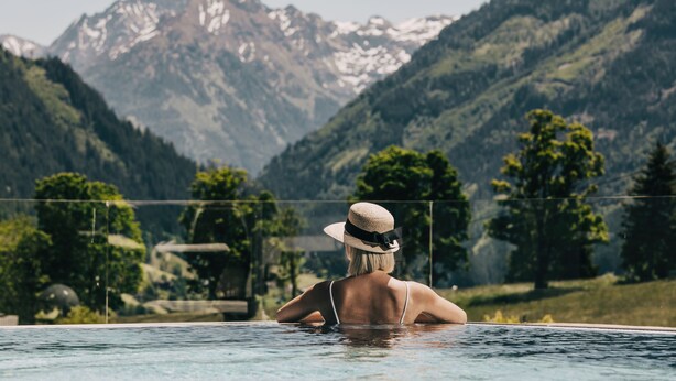 A person in a swimming pool with a mountain view in the background.