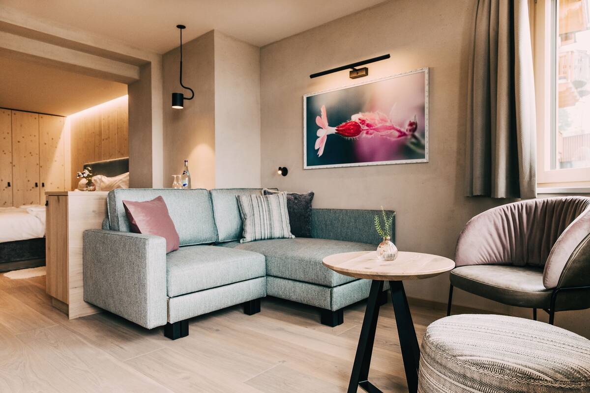 Una sala de estar moderna con un sofá modular, una mesa de centro redonda y un sillón cómodo.