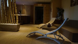 Ein stilvoller Lounge-Bereich mit Liegesessel, kleinem Tisch und dekorativer Pflanzenanordnung.