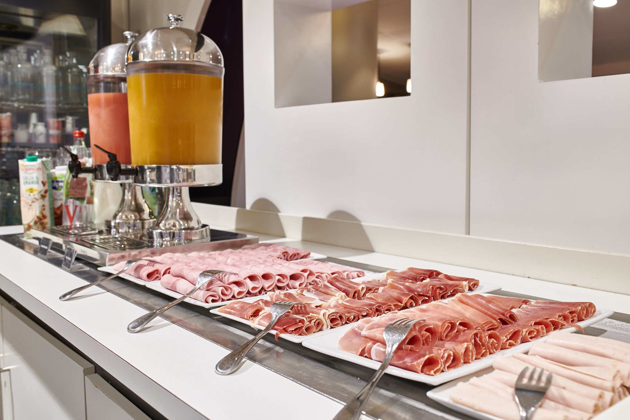Un buffet proposant différentes sortes de viandes et un espace dédié aux boissons.