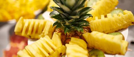 A plate of sliced pineapple and kiwi arranged on a white plate.