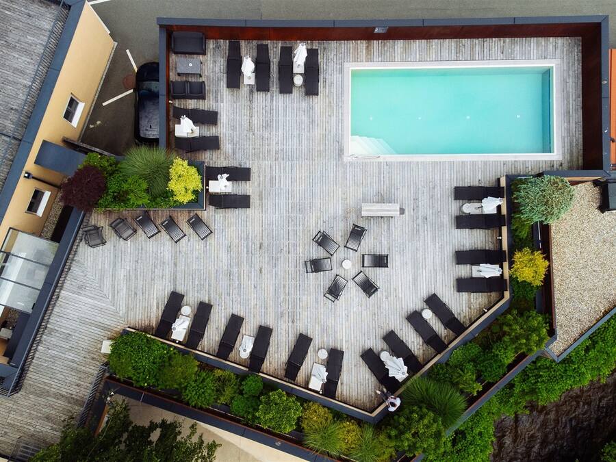 An aerial view of a rooftop with a swimming pool, lounge area, and outdoor seating.