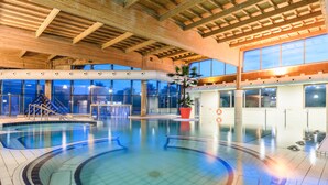 An indoor swimming pool with a wooden ceiling and large windows. - Hôtel Les Terrasses d'Atlanthal (Anglet)