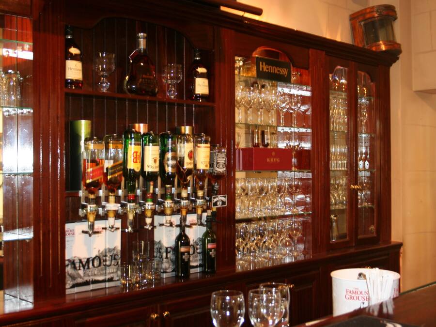 A bar area with various liquor bottles and glasses.