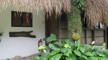 A building with a sign reading "IFUGAO," a thatched roof, and a fire extinguisher mounted on the wall.