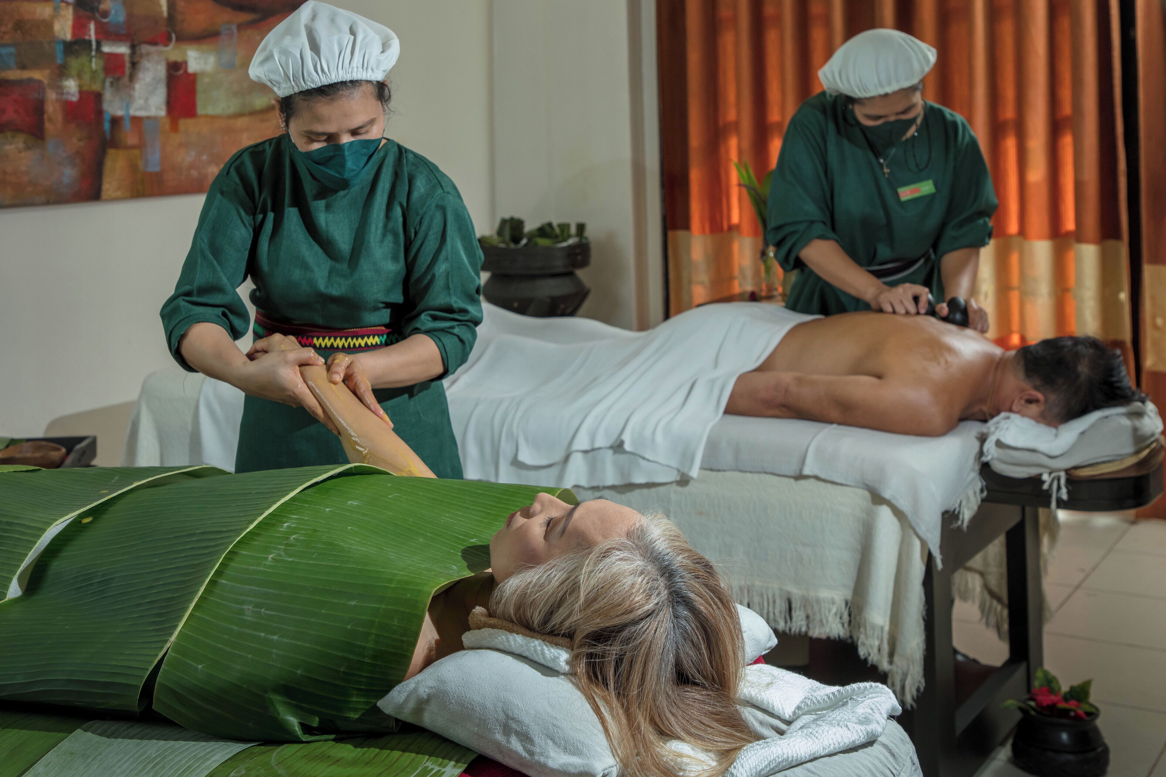 Une salle de massage où deux clients reçoivent des soins.