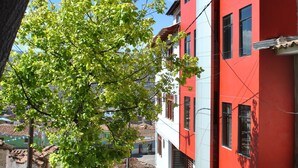 A red and white building with a tree in front. - Wifala Thematic Hotel (Cusco)