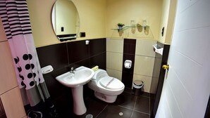 A bathroom with a sink, toilet, mirror, and shelves with toiletries. - Wifala Thematic Hotel (Cusco)
