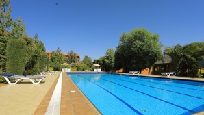 A swimming pool with lounge chairs and a tiled deck. - Yaya Africa Athletics Village (Sululta)