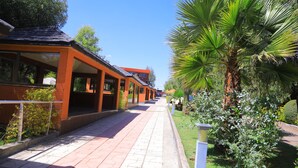 A pathway leading to a building with large windows and a covered outdoor area. - Yaya Africa Athletics Village (Sululta)
