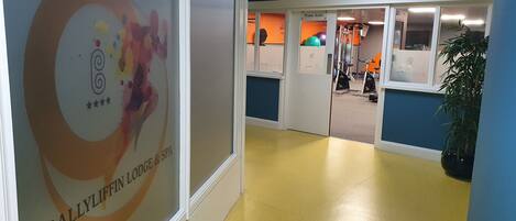 A hallway with a sign for '4* Ballyliffin Lodge & Spa' and a fitness studio in the background.