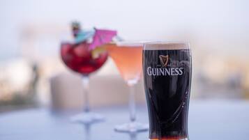Um copo de Guinness sobre uma mesa, com fundo desfocado.