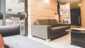 Un soggiorno moderno con un divano grigio, un tavolino da caffè e una libreria.