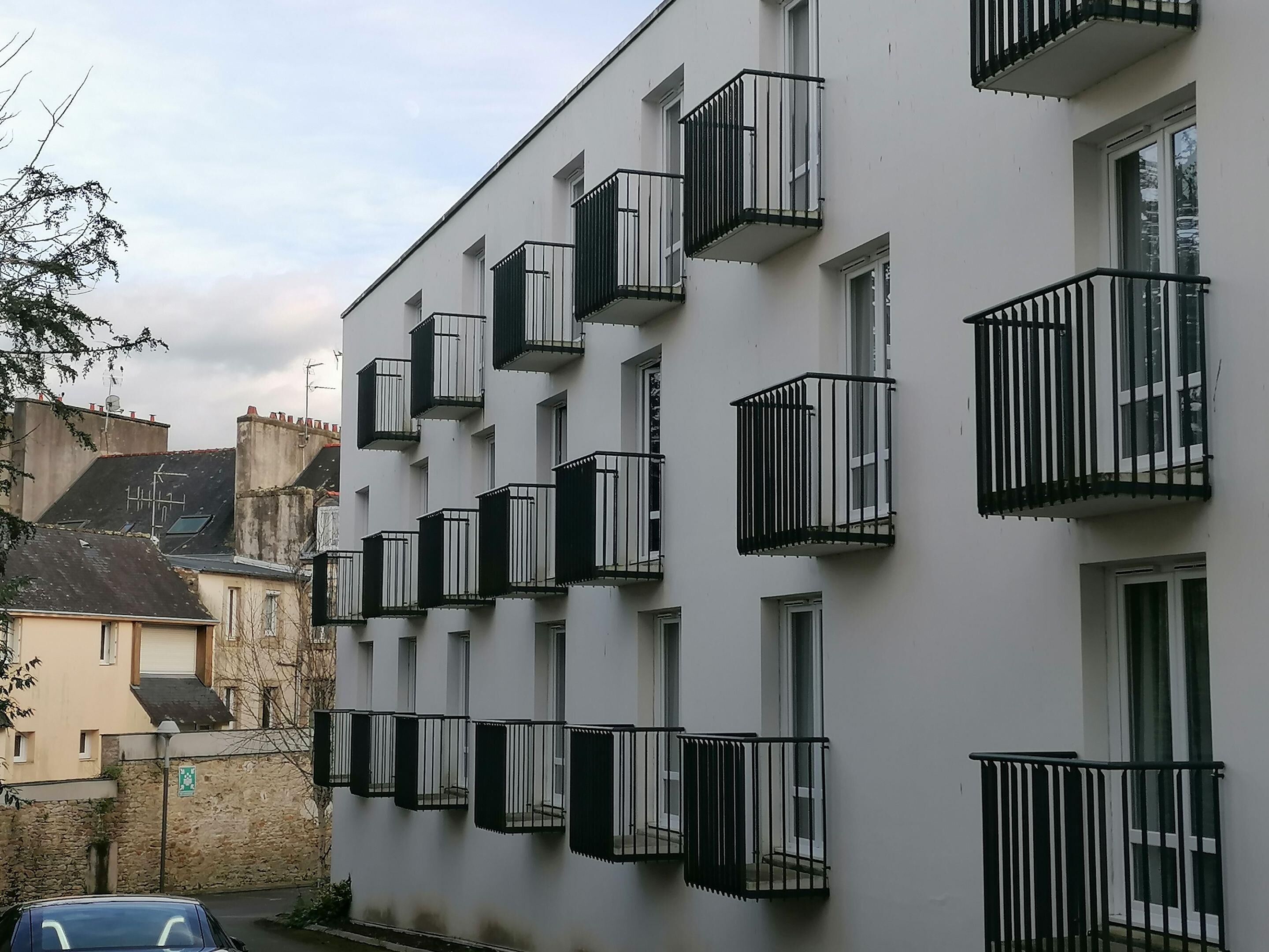 A multi-story building with balconies and windows.