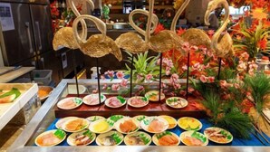 A buffet with various dishes and decorative swan figures. - Inzone Garland Hotel Jinan (Jinan)