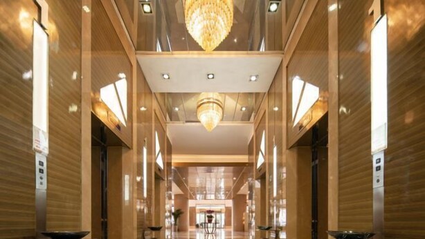 A spacious, modern lobby with a central chandelier, polished floors, and symmetrical design. - Inzone Garland Hotel Jinan (Jinan)