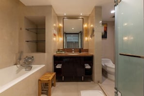 Un baño moderno con bañera, tocador con espejo y zona de ducha.