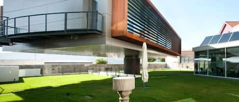 A modern building with a flat roof, a large glass facade, and a wooden accent wall.