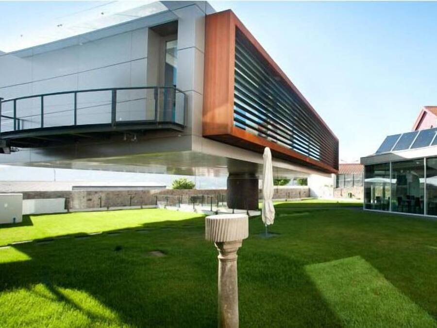 A modern building with a flat roof, a large glass facade, and a wooden accent wall.