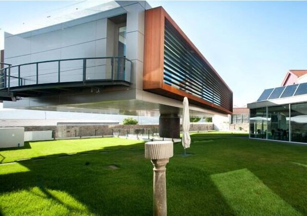 A modern building with a flat roof, a large glass facade, and a wooden accent wall.