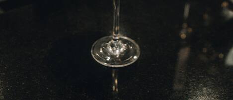 A martini glass with a frothy top on a bar counter.