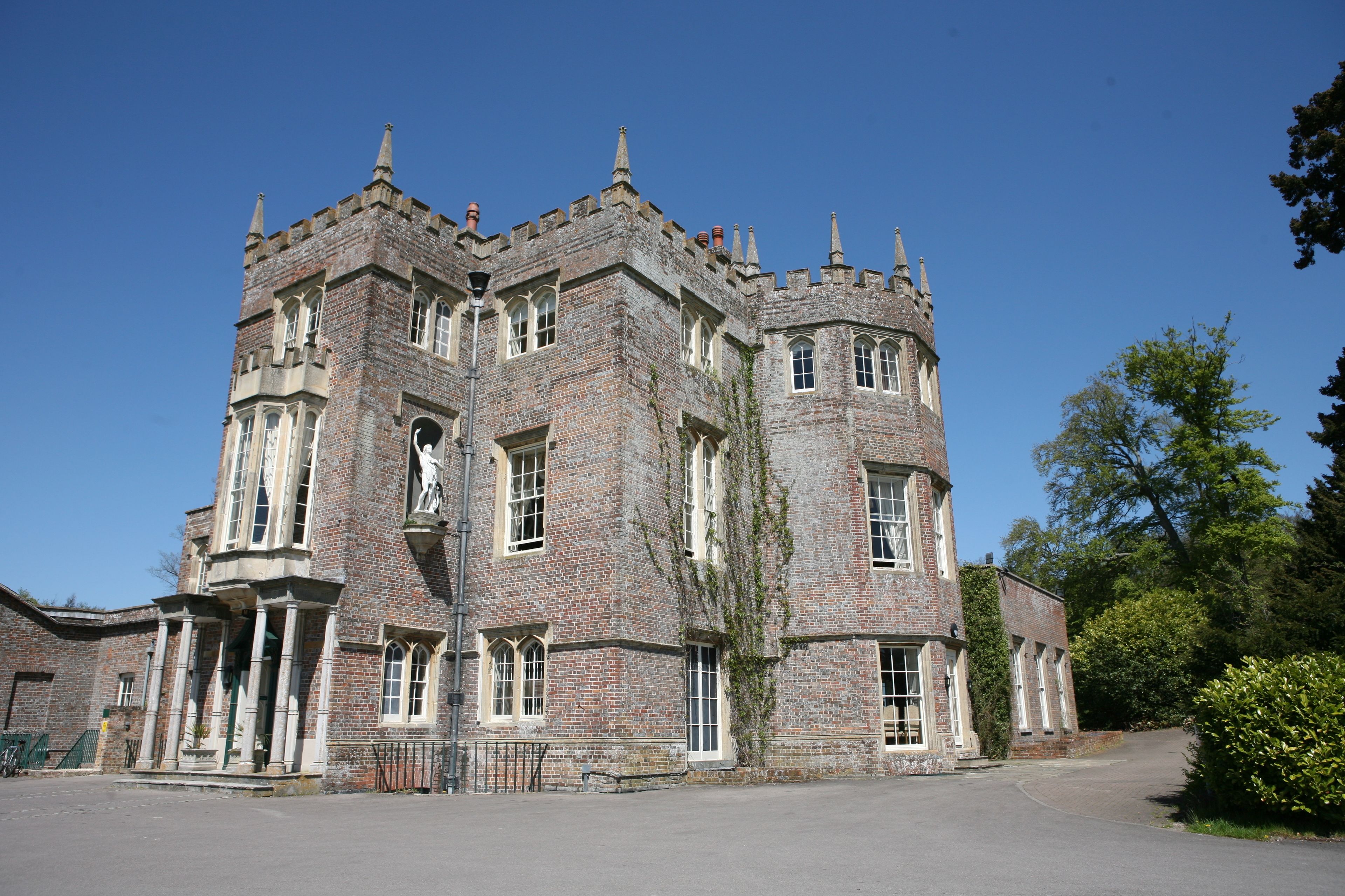 A large, historic building with a central tower, multiple windows, and a symmetrical facade.