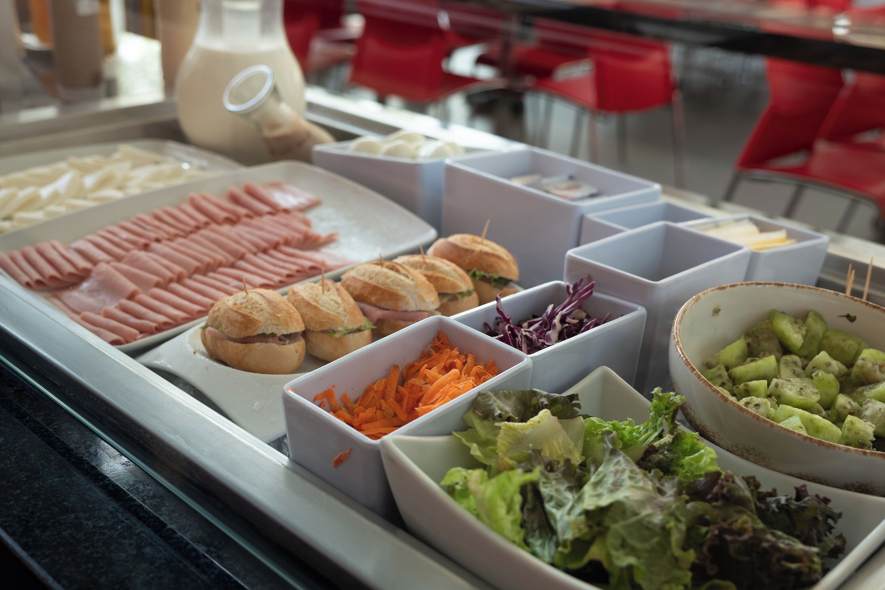 Un buffet proposant une variété de plats, notamment des viandes, des sandwichs et des salades.