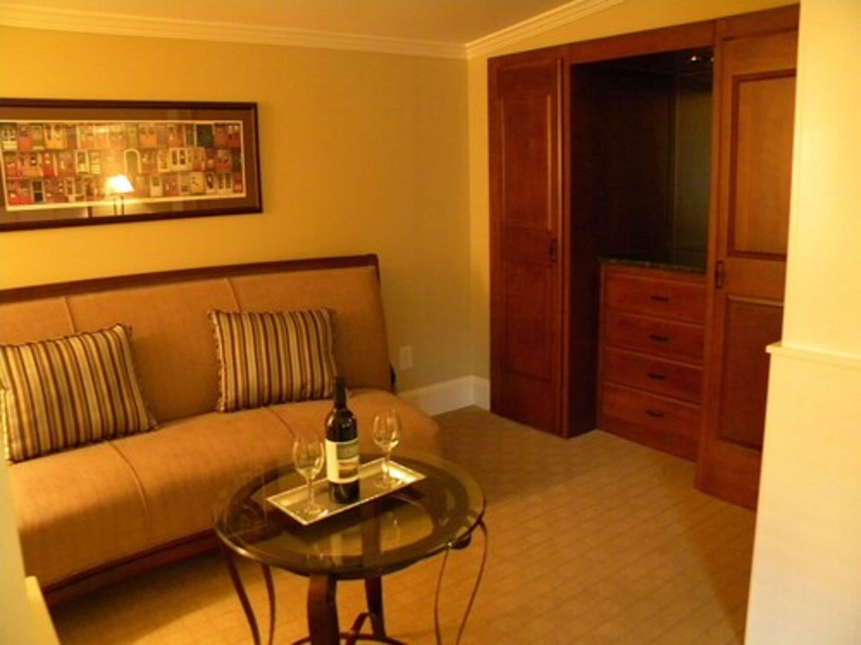 Ein Wohnzimmer mit einer Couch, einem Glastisch und einem Schrank.