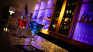 A bar area with a granite countertop, a blue cocktail glass, and a red cocktail glass.