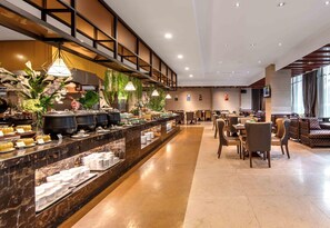 A hotel lobby with a buffet area, seating arrangements, and a large window providing natural light. - White Horse Lake Jianguo Hotel (Hangzhou)