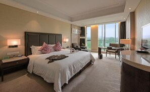A hotel room with a large bed, a desk, a chair, a TV, and a balcony with a view. - White Horse Lake Jianguo Hotel (Hangzhou)