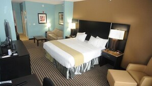 Una habitación de hotel con una cama grande, un escritorio, una silla y un televisor.