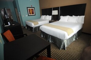 Quarto de hotel com duas camas, uma escrivaninha, uma cadeira e uma televisão.