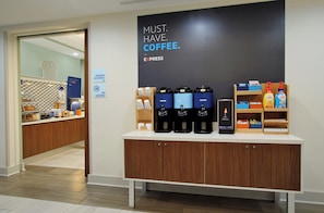 A coffee station with multiple coffee dispensers, a sign stating 'MUST HAVE COFFEE,' and a maximum occupancy sign. - Holiday Inn Express Somerset by IHG (Somerset)