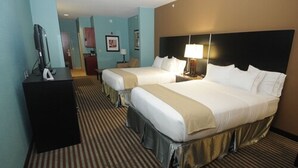 Una habitación de hotel con dos camas, televisión, escritorio y lámpara.