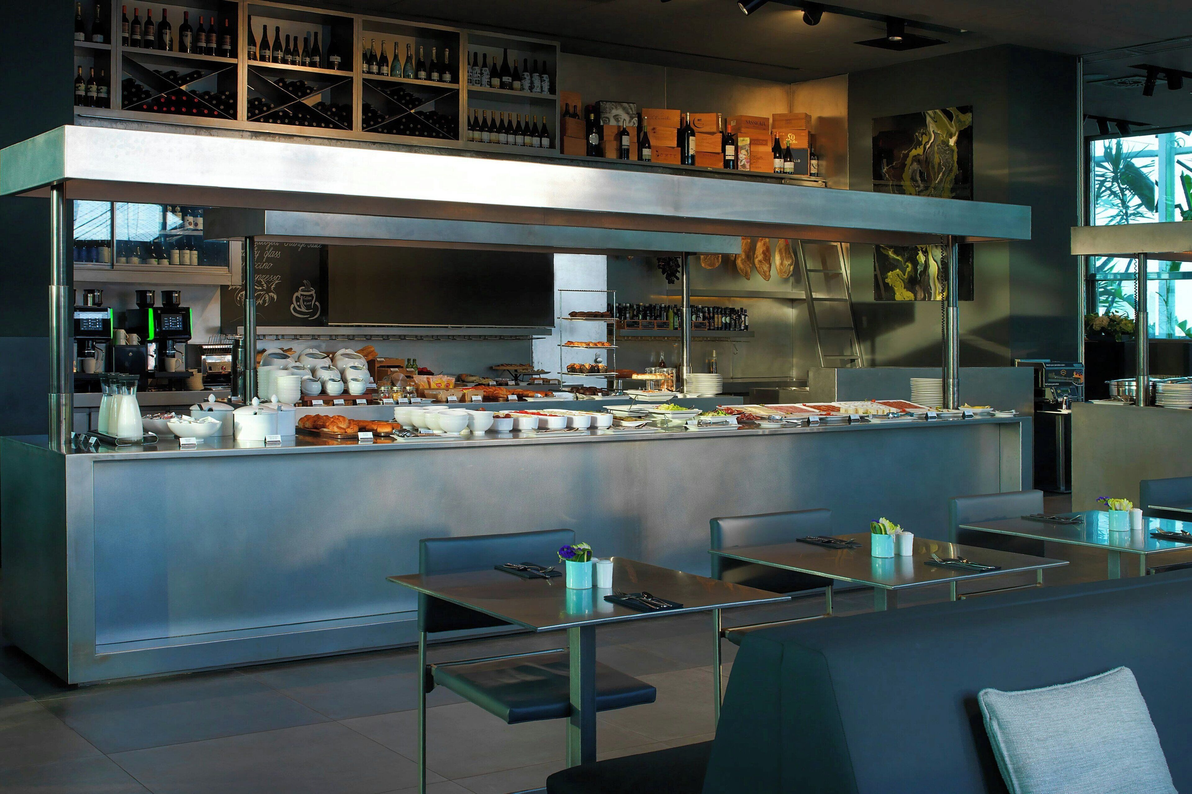 Un restaurant moderne doté d’un buffet, d’un espace pour s’asseoir et de présentoirs à vin.