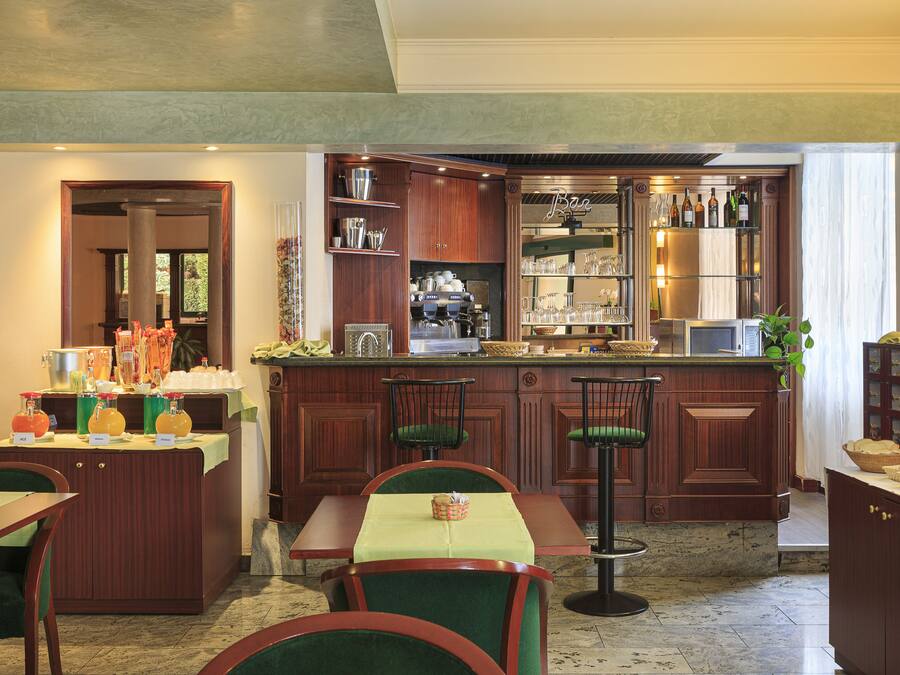 A restaurant with wooden cabinetry, bar stools, and a buffet area.