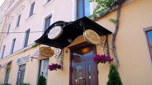 Un hotel con un letrero que dice "HOTEL ROYAL STREET" y un letrero más pequeño debajo.