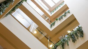 A multi-level interior with glass railings and greenery. - Hotel Font d'Argent Canillo (Canillo)