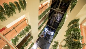 A multi-level atrium with a central open space, surrounded by balconies with green plants. - Hotel Font d'Argent Canillo (Canillo)