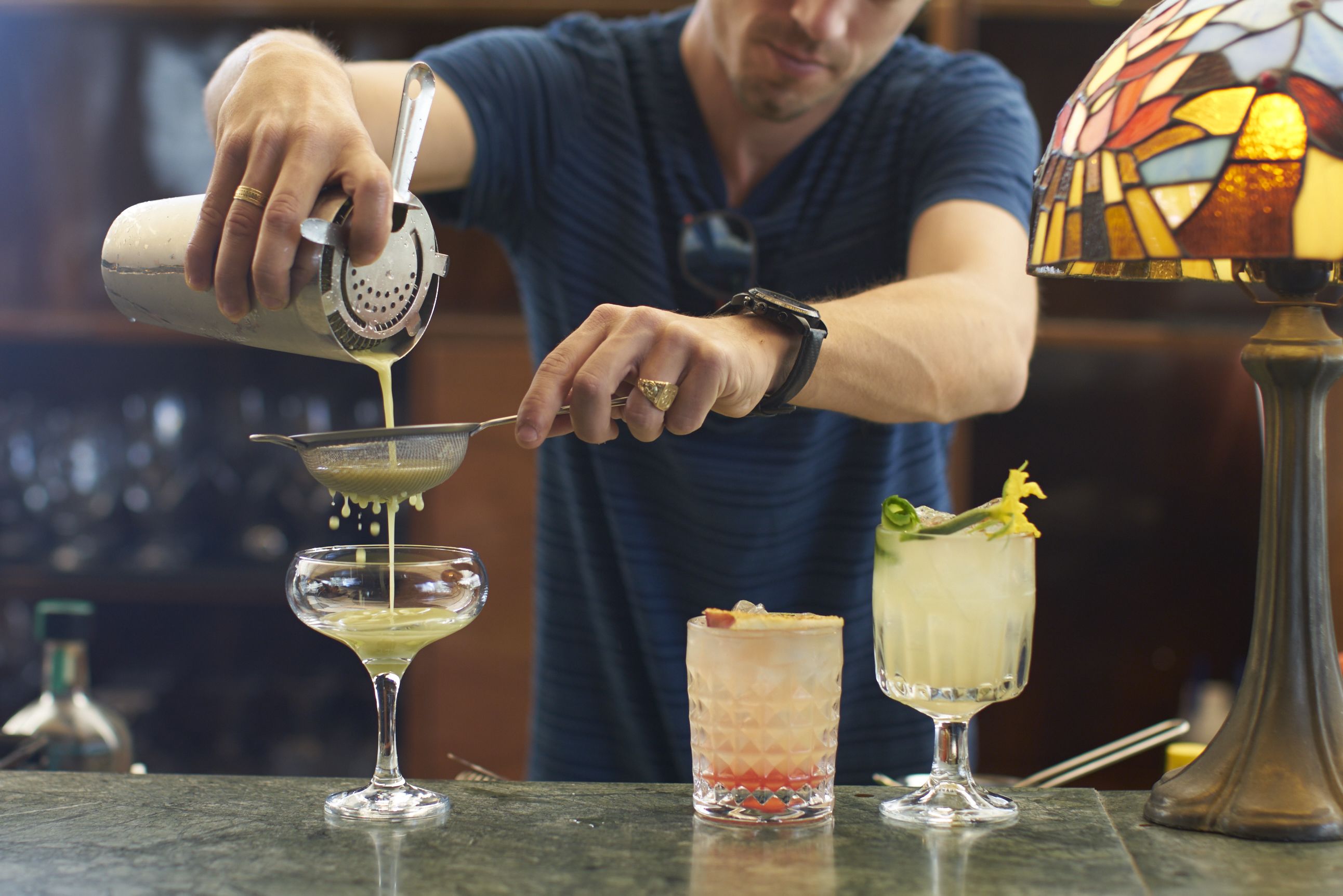 A bartender preparing drinks in a bar setting.